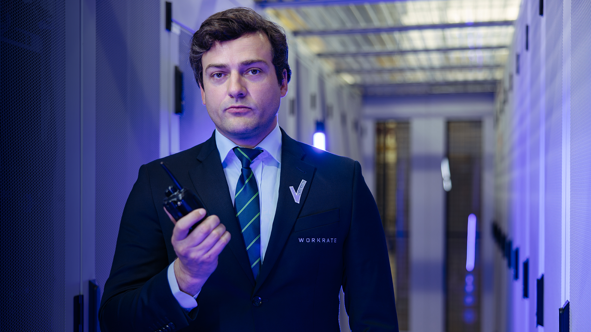 Male security guard standing in datacenter environment holding a porto