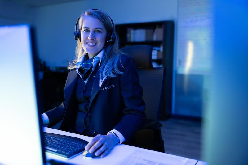 Workrate female security guard monitoring screen in control room