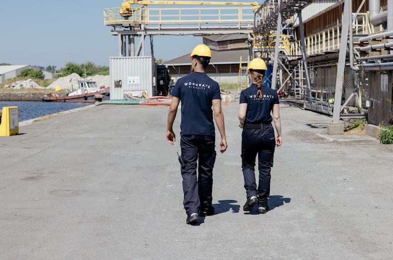 Workrate male and female security guards walking and inspecting port area